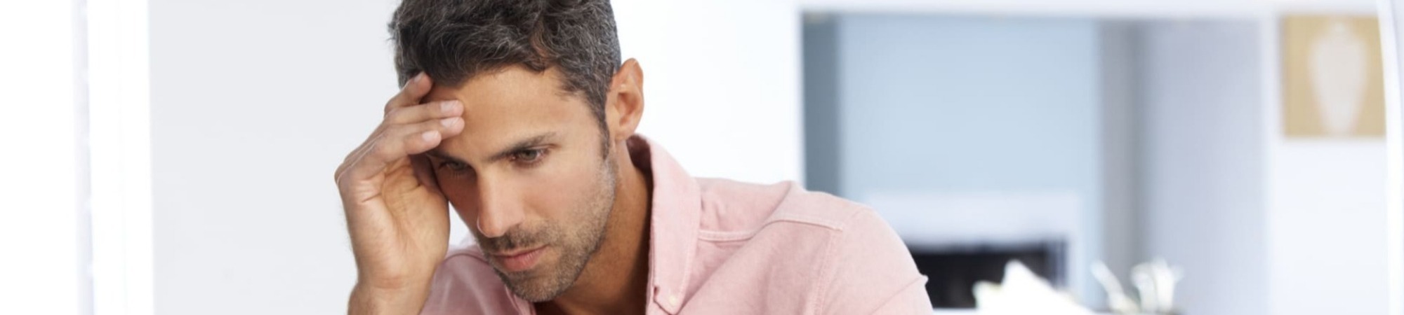 Stressed man working at laptop in home office