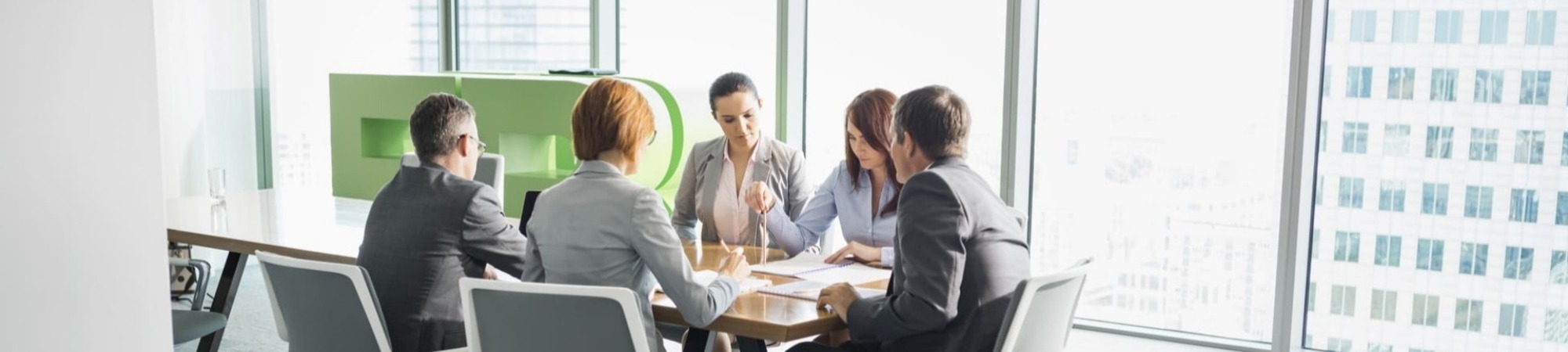 Businesspeople in conference room seated around a table 